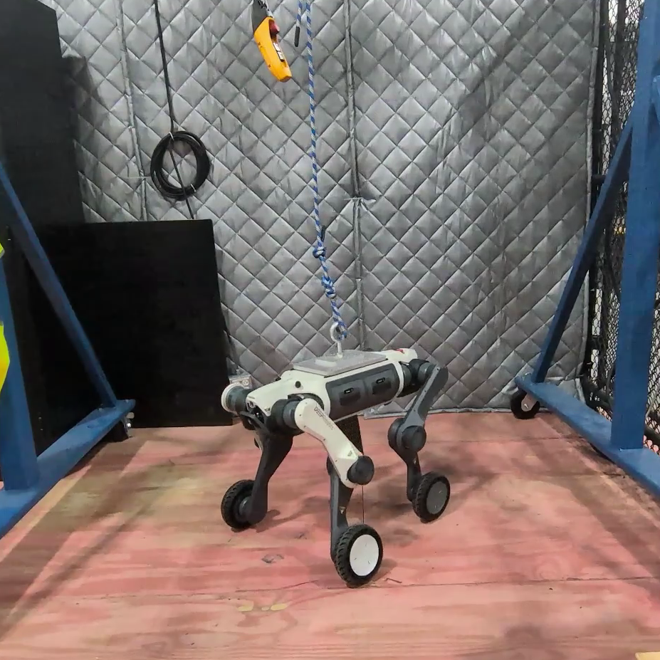 A quadrupedal robot standing upright, supported by a crane system
